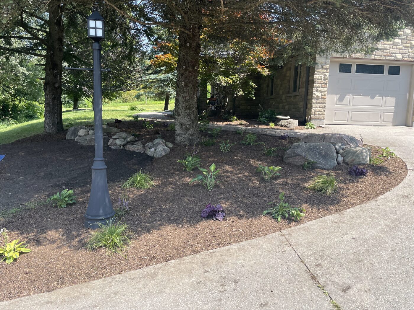 The same bed after with a lamp post, fresh mulch and new plantings