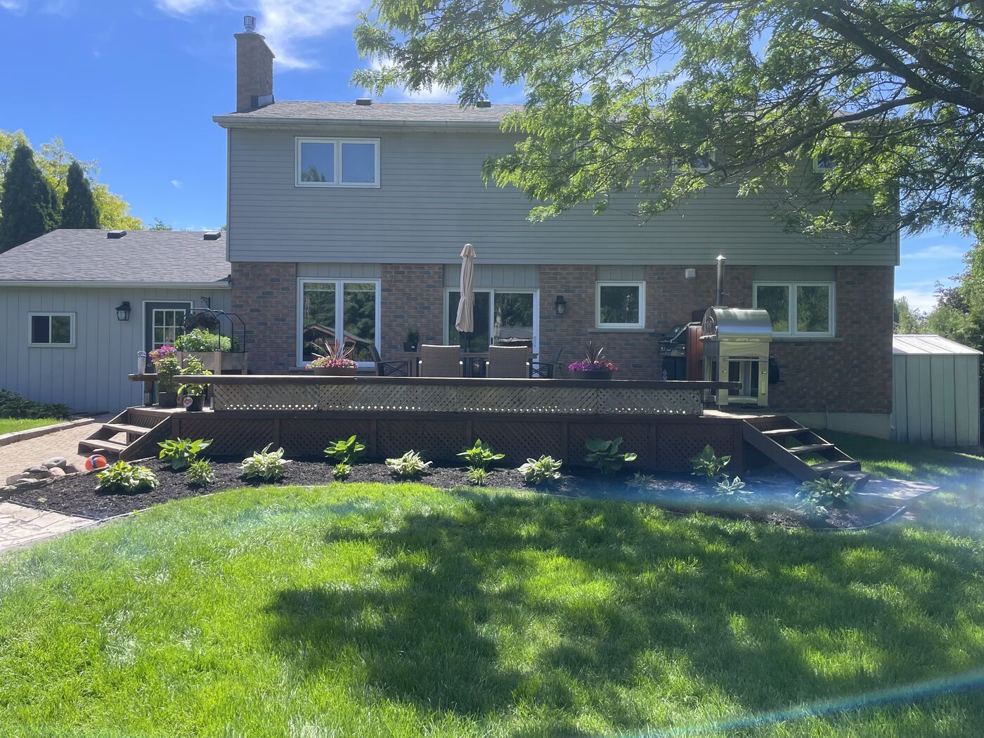 Backyard with deck and freshly planted garden bed