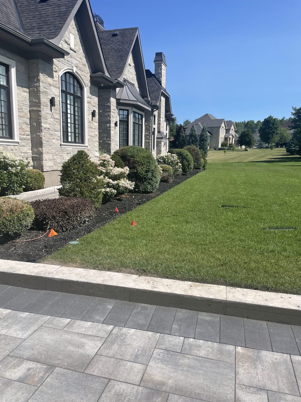 Fresh front garden beds and shrubs at a stone home