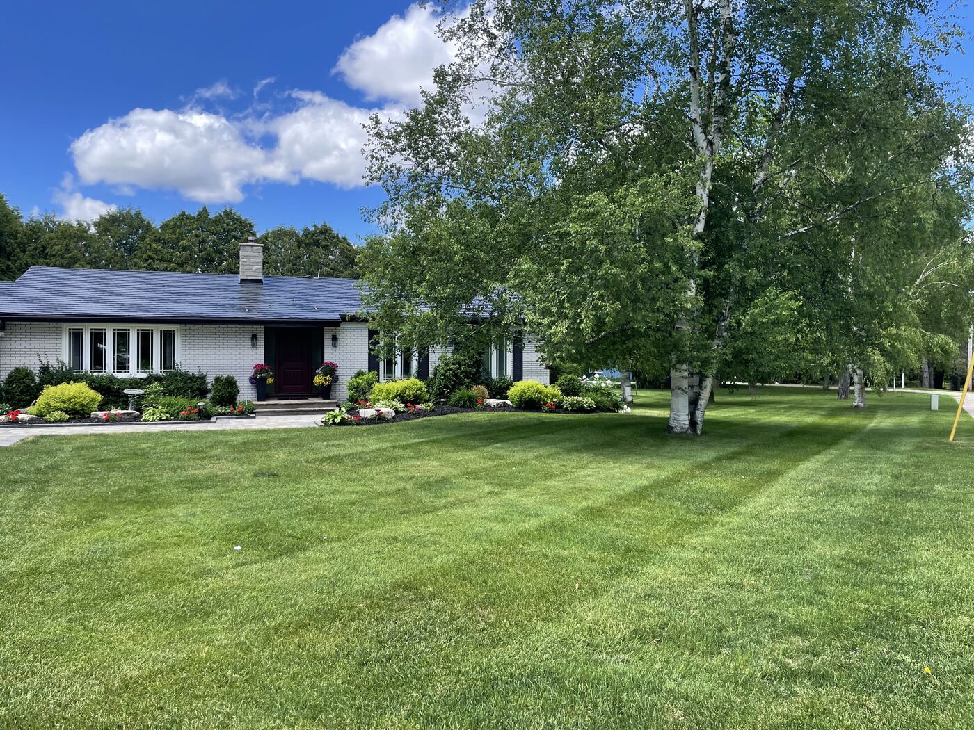 Manicured lawn and landscaped property by Royal Landscaping in Caledon